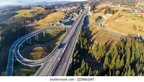Poland. Zakopianka highway with newly opened tunnel in November 2022.  Multilevel spaghetti junction with traffic circles, viaducts, slip roads and traffic near Skomielna Biała. Aerial panorama