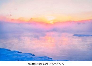 The polar vortex storms over Lake Michigan. Mist carries off the frozen lake during a beautiful, colorful sunrise. - Powered by Shutterstock