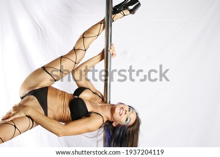 Pole Acrobat displaying moves on a pole