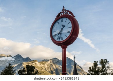 A pole with a clock at the top of a mountain