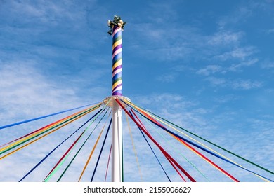 A pole with colored ribbons and flowers on a traditional English Maypole dancing day