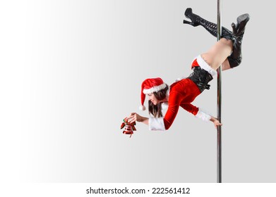 Pole dancer girl as Santa's helper decorating something