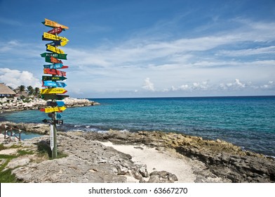 Pole indicating the direction and distance to several countries, from the Mayan Riviera