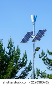 Pole With Innovative LED Street Light Powered By Solar Cells And Small Vertical Wind Generator, Blue Sky Background