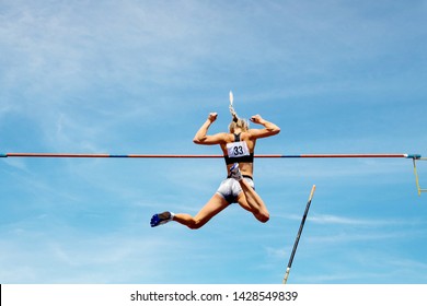 pole vault woman vaulter successful attempt to fly background in blue sky - Powered by Shutterstock