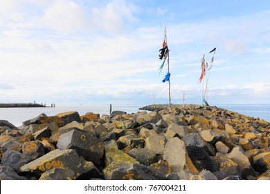 Poles With Colored Rope And Plastic Waving In The Wind On Breakwater Or Pier In The Wadden Sea At The Entrance To The Port Of Harlingen The Netherlands