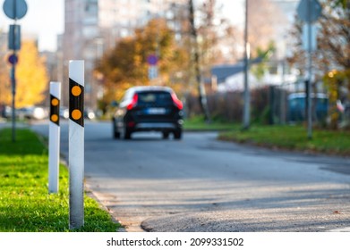 Poles At The Traffic Safety Speed Bumps In Residential Area, Blurred Background With A Car, Closeup