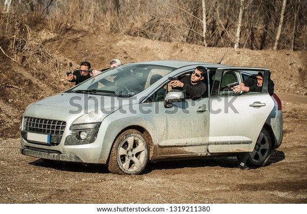 Police agent and bodyguard training action gun\
shooting from car. Special agent team weapons training and course\
on outdoor shooting\
range