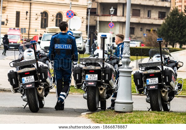 Police\
agent on motorcycle, Romanian Police (Politia Rutiera) car\
patrolling streets to avoid curfew breaches amid the spread of the\
COVID-19 in downtown Bucharest, Romania,\
2020