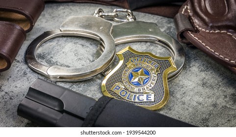 Police badge, holster and handcuffs on stone background. Macro shoot