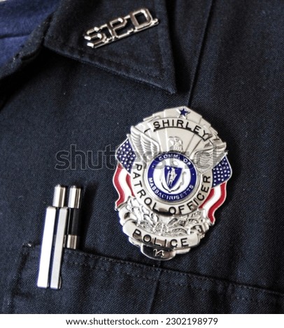 Police badge on uniform with pens visible
