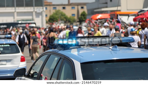 police car with blue flashing\
lights above during escort and protest demonstration of\
people