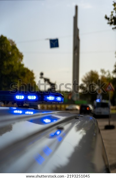 Police car blue lights in background soviet monument\
in Riga