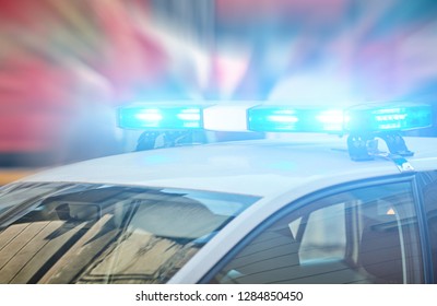 Police car with blue lights on the crime scene in traffic / urban environment. - Shutterstock ID 1284850450