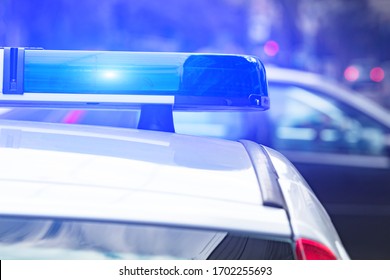 Polizeiauto mit blauen Lichtern auf der Kriminalszene in Verkehr / städtischen Umwelt.