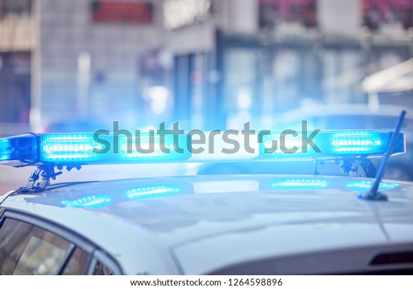 Police car with blue lights on the crime
scene in traffic / urban
environment.