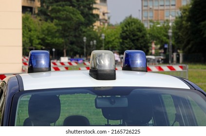 police car with blue lights sirens in the city with houses and building in background - Shutterstock ID 2165726225