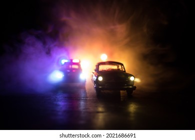 Police car chasing a car at night with fog background. 911 Emergency response police car speeding to scene of crime. Selective focus - Shutterstock ID 2021686691