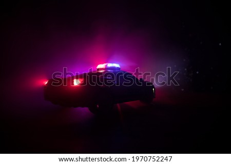 Police car chasing a car at night with fog background. 911 Emergency response police car speeding to scene of crime. Creative decoration. Selective focus
