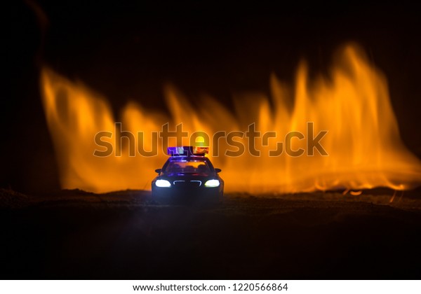 Police car chasing a car at night with fog\
background. 911 Emergency response police car speeding to scene of\
crime. Selective focus