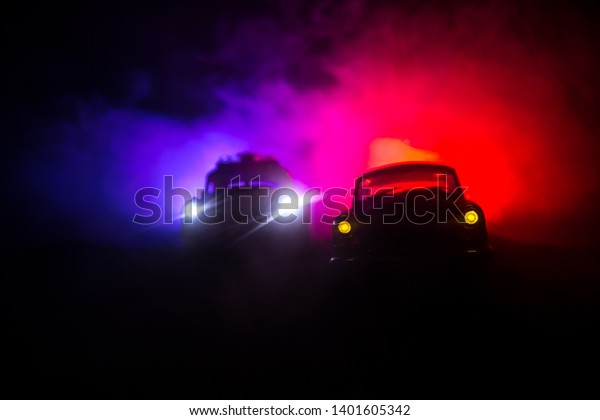 Police car chasing a car at night with fog
background. 911 Emergency response police car speeding to scene of
crime. Selective focus