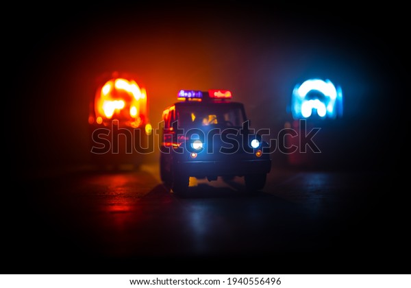 Police car chasing a car at\
night with fog background. 911 Emergency response police car\
speeding to scene of crime. Creative decoration. Selective\
focus