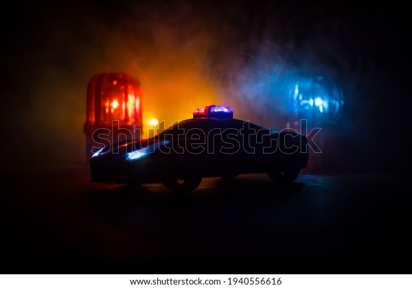 Police car chasing a car at
night with fog background. 911 Emergency response police car
speeding to scene of crime. Creative decoration. Selective
focus