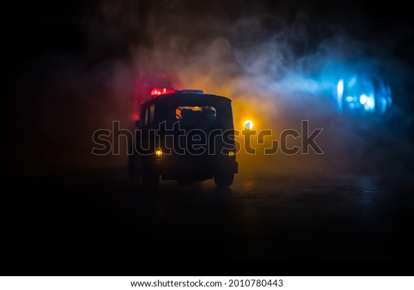 Police car chasing a car at\
night with fog background. 911 Emergency response police car\
speeding to scene of crime. Creative decoration. Selective\
focus