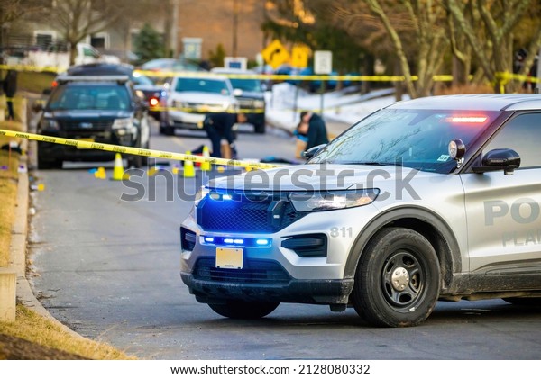 Police car with emergency lights on road with\
caution tape in the back