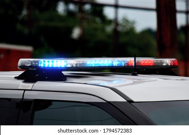 Police Car Flashing Lights Close Up. Top Of A Police Car With Lights Flashing In Daytime. Blue And Red Flashing Lights At A Crime Or Accident Scene. Day Time Scene.