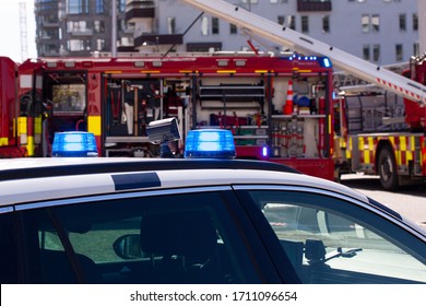 Police Car With Flashing Lights In Front Of A Fire Truck.