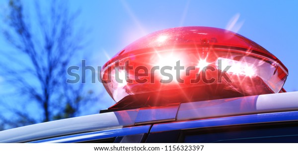 Police car with focus on red siren light.\
Colorful red siren on the roof of a police car in a real\
intervention. Beautiful red siren lights activated in full\
policemen operation. Red light\
flasher.