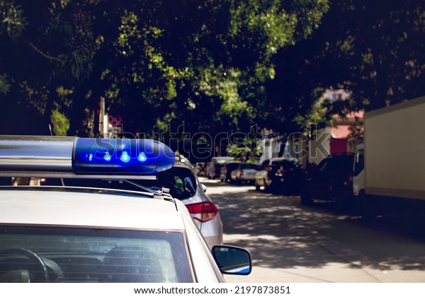 Police car with glowing lights, flashing\
lights in an urban\
environment