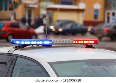 Police Car Lights In City Street At Winter Day With Cars Traffic In Blurry Background