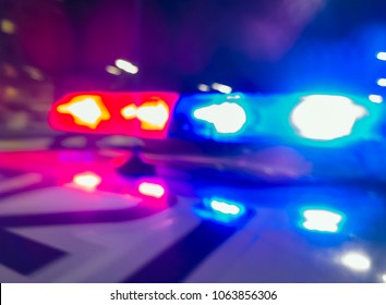Police car lights in night time, crime scene, night patrolling the city. Abstract blurry image.