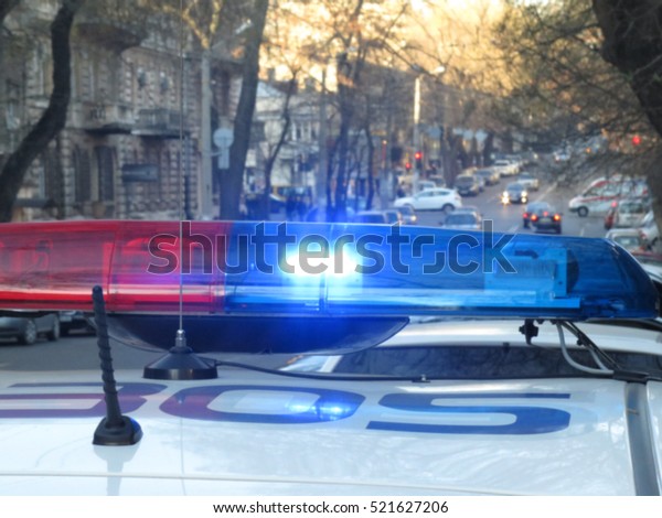   Police car with lights turned on. City lights on the\
background. With vintage and blur effect.                          \
     