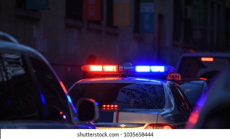 Police Car At Night With Flashing Lights. 