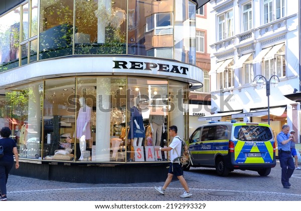 Police car outside cashmere clothing Repeat office\
in Germany, buy women\'s and men\'s clothing, modern retail store in\
city glass windows, bargains, seasonal sales, discounts, Frankfurt\
- August 2022