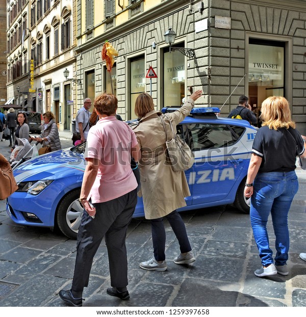 Police car. People walk along\
the street. Modern urban landscape. Italy, Florence - April 17,\
2018 