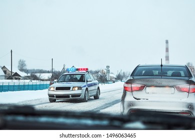 Police Car With Red And Blue Flshaer Lights Stopped Car On A Winter Snowy Road