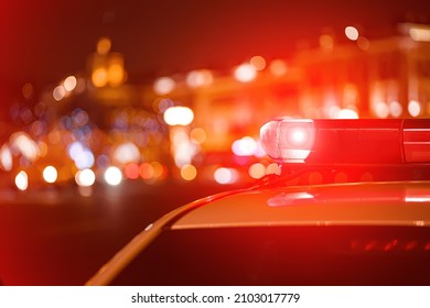 Police car red color emergency light (siren) at the night city lights background. 