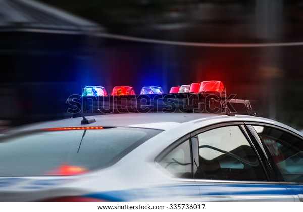 A police car rushes to the emergency call with lights turned on