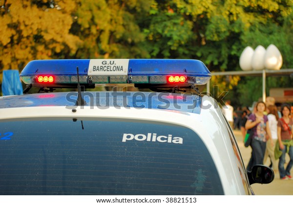 police\
car with a siren in city park of barcelona,\
spain