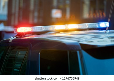 Police Car Traffic Stop With Three Siren Lights Simultaneously Blinking - Red, Yellow And Blue .