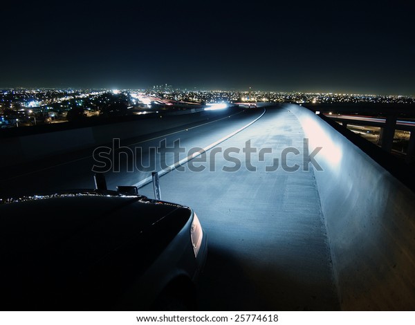 A police\
car at work at night on a highway\
bridge.