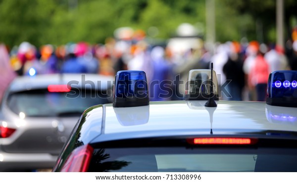 Police cars with flashing sirens\
during the demonstration of people on the streets of the\
city