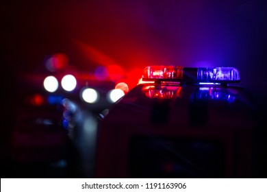 Police cars at night. Police car chasing a car at night with fog background. 911 Emergency response police car speeding to scene of crime. Selective focus - Shutterstock ID 1191163906