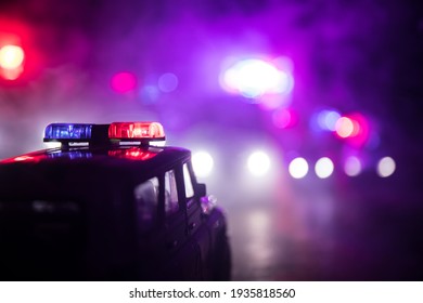 Police cars at night. Police car chasing a car at night with fog background. 911 Emergency response police car speeding to scene of crime. Selective focus - Shutterstock ID 1935818560