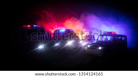 Police cars at night. Police car chasing a car at night with fog background. 911 Emergency response police car speeding to scene of crime. Selective focus