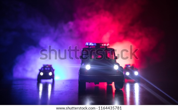Police cars at night. Police car
chasing a car at night with fog background. 911 Emergency response
police car speeding to scene of crime. Selective
focus